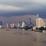 Taksin Bridge with Chao Phraya River, Bangkok Downtown. Thailand. Financial district and business centers in smart urban city. Skyscraper and high-rise buildings with storm rain.