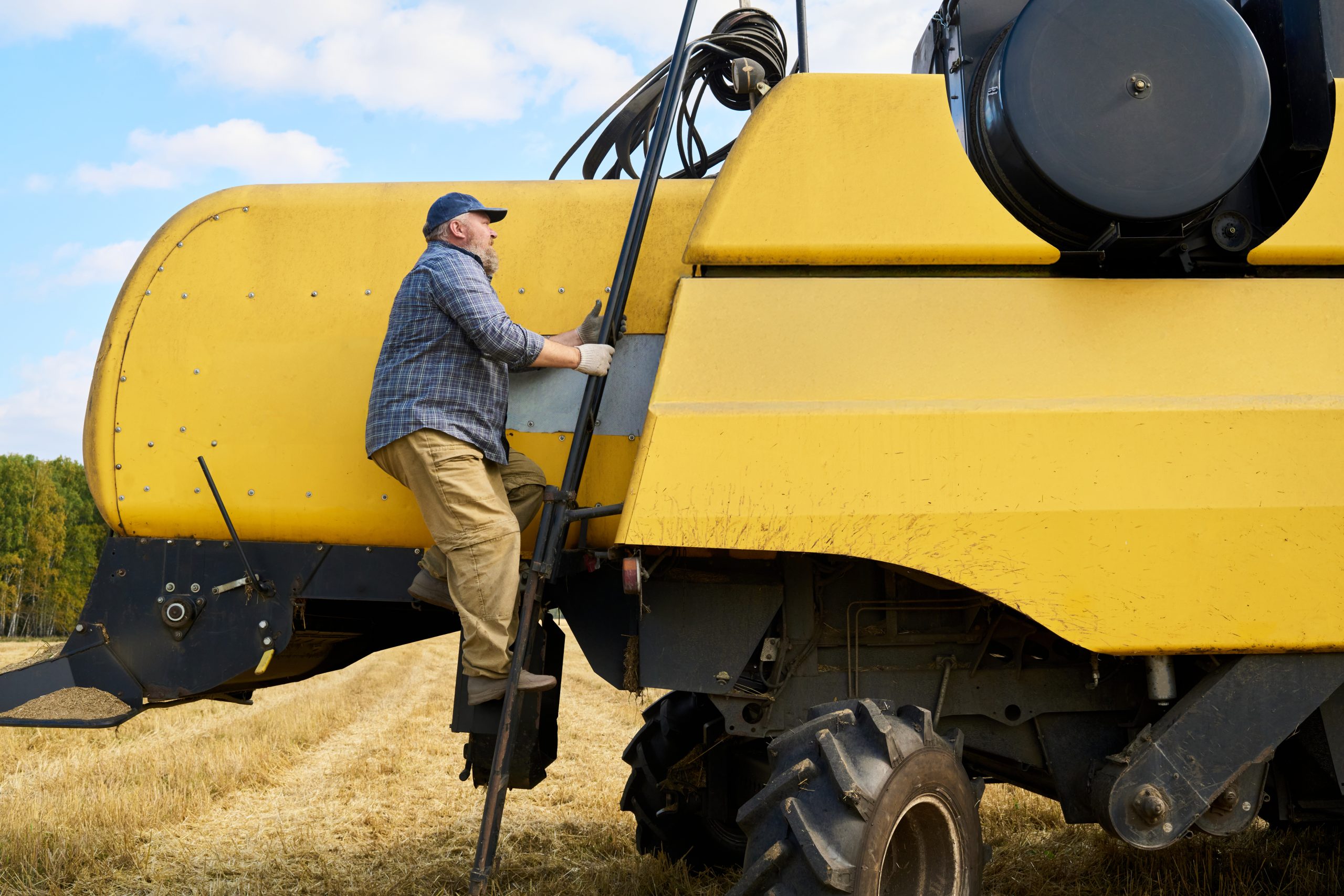 Middle Aged Caucasian Man Climbing Ladder Entering Agricultural Combine Harvester