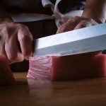 Male hands of a chef cutting a delicious loin of fresh bluefin t