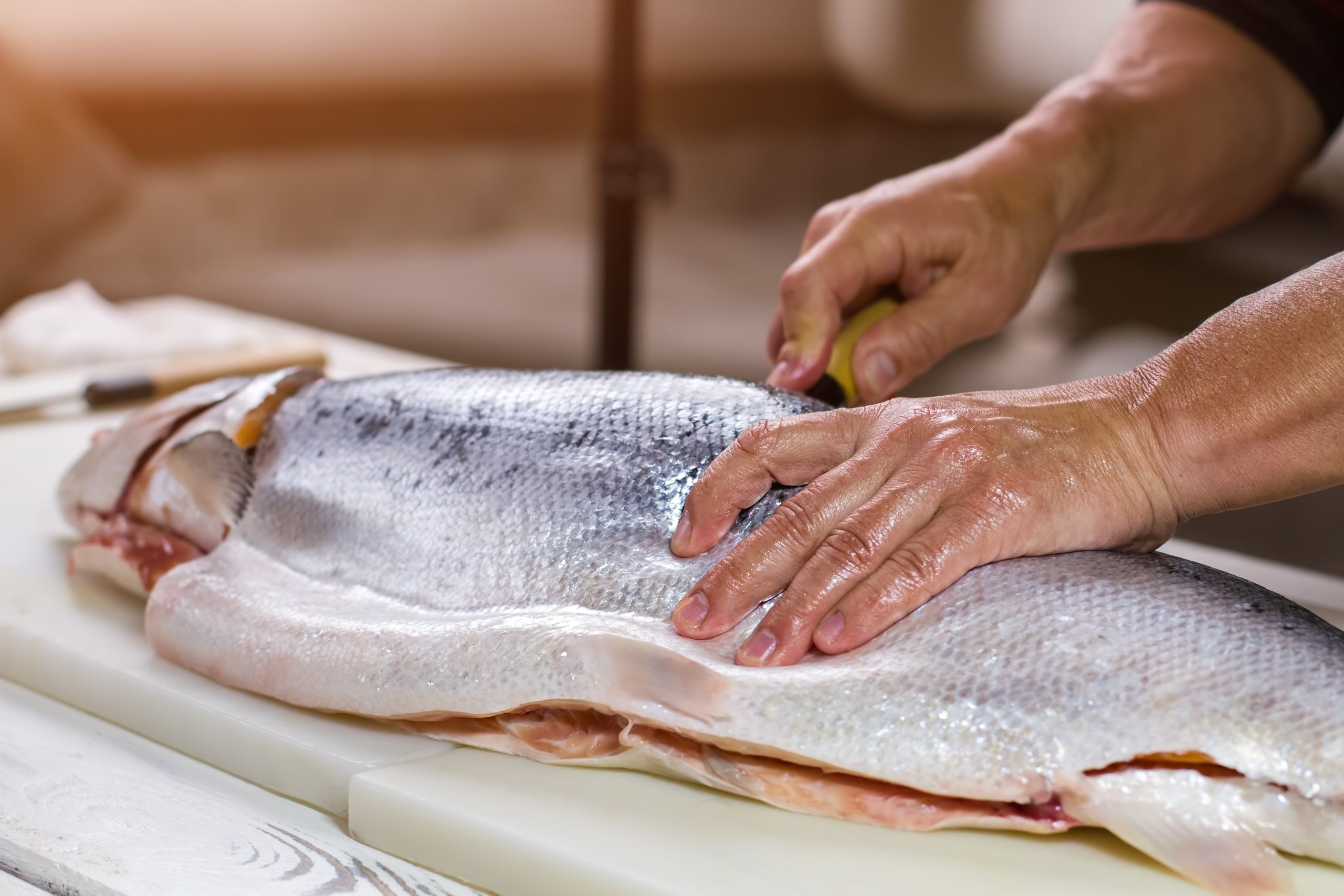 Male hand on raw fish.