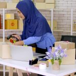 Beautiful muslim female merchandiser preparing parcel at the off